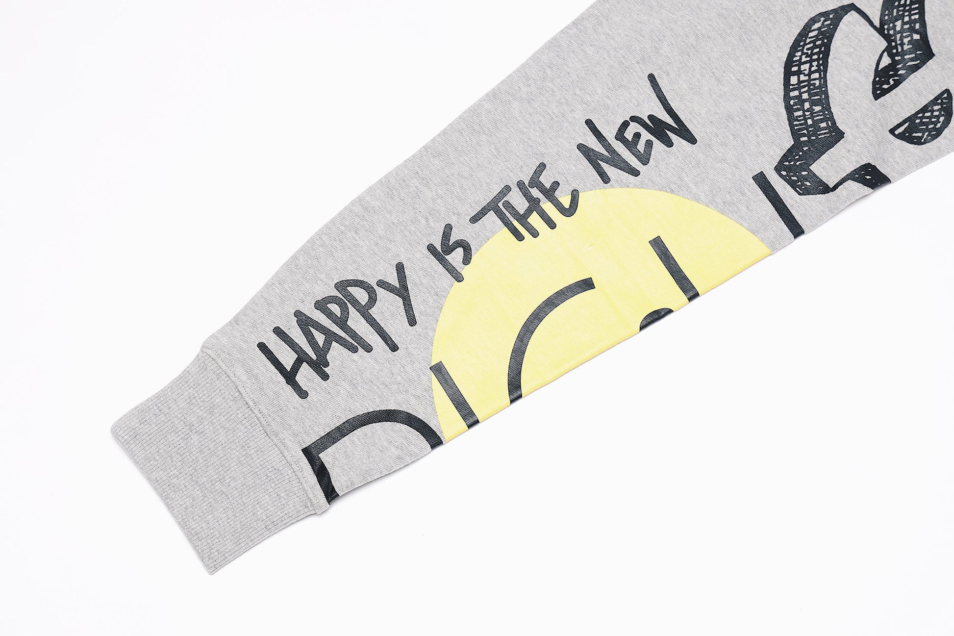 Graphic statement sweater sleeve featuring bold text and graphic design with a yellow sun motif.