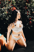 Reflective bikini set worn by a woman in a garden setting, showcasing a triangle top and high cut bottom.