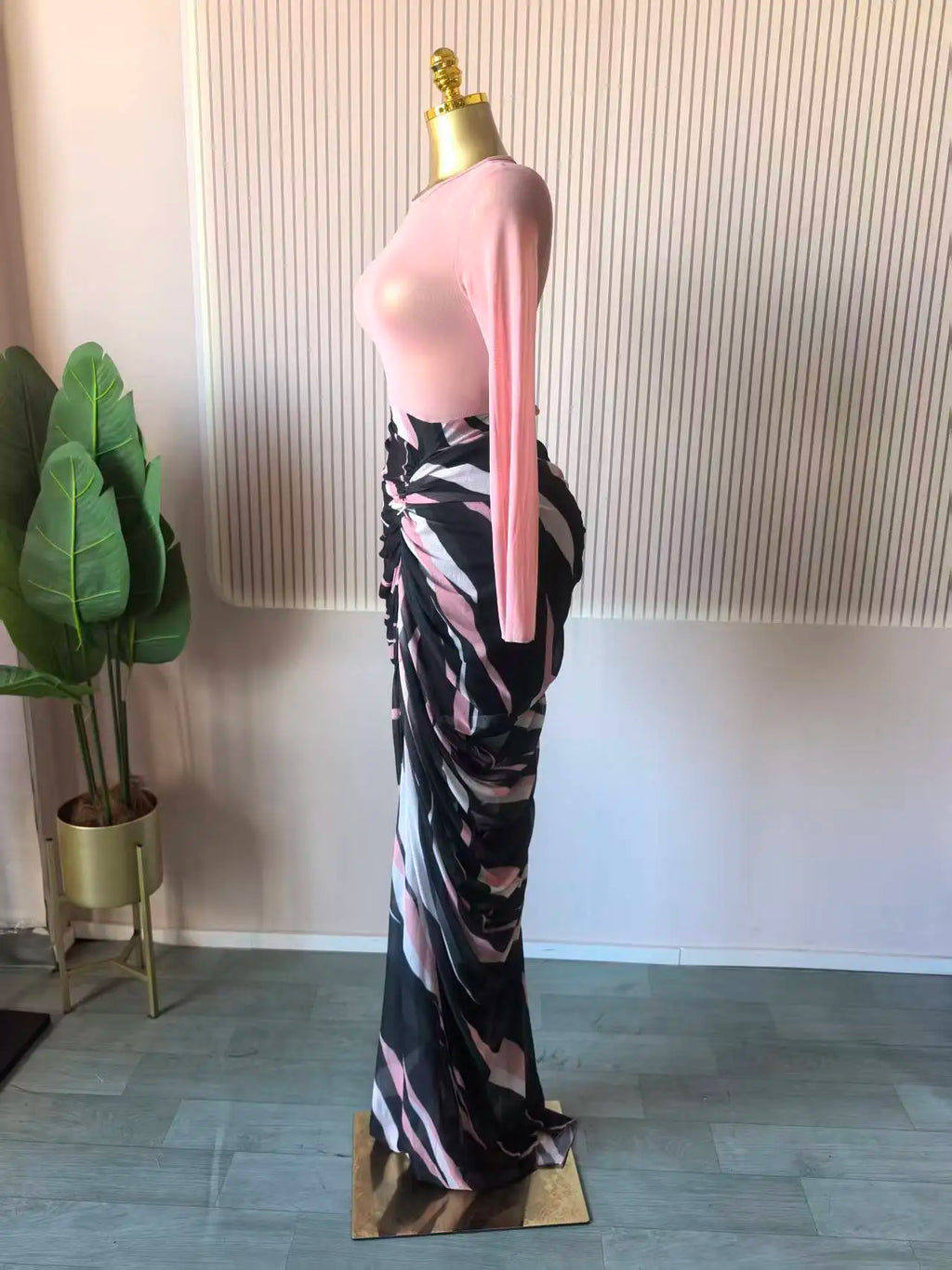 Alt Tag: Sculpted Mirage Draped Maxi Dress side view on mannequin, pink long-sleeve knit top with abstract printed draped maxi skirt