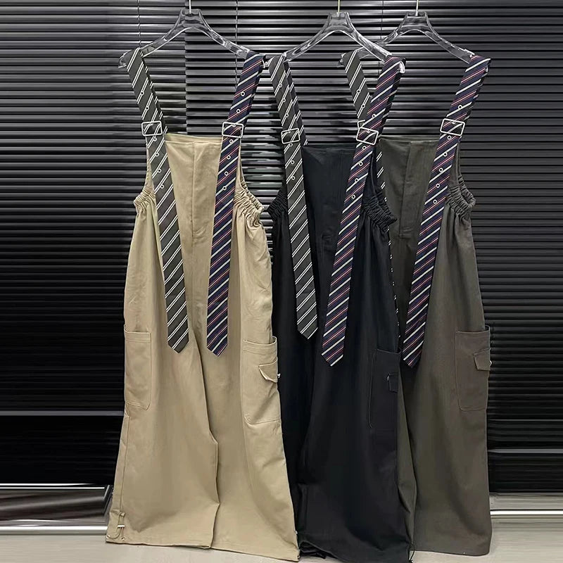 Executive suspender jumpsuit in beige, black, and olive green, featuring detachable striped ties and wide-leg design.