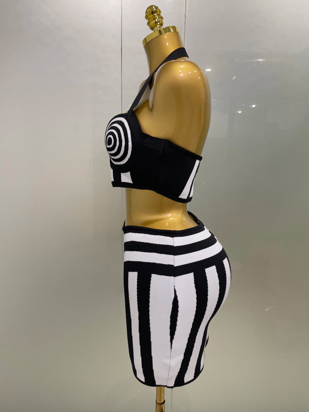 Alt Tag: Optical Illusion Halter Bandage 2-Piece Set black-and-white spiral halter crop top and geometric bandage skirt side view