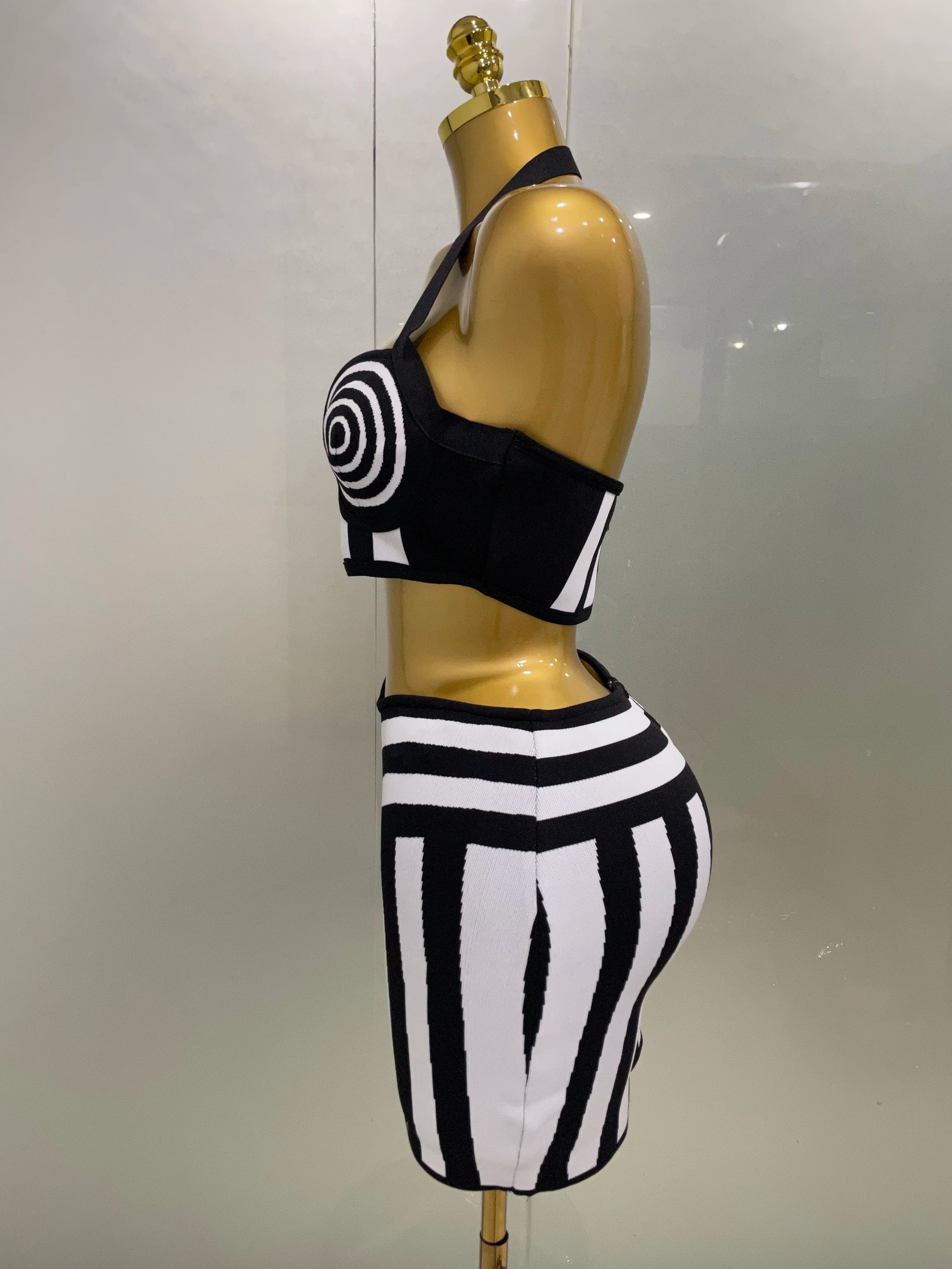 Alt Tag: Optical Illusion Halter Bandage 2-Piece Set black-and-white spiral halter crop top and geometric bandage skirt side view