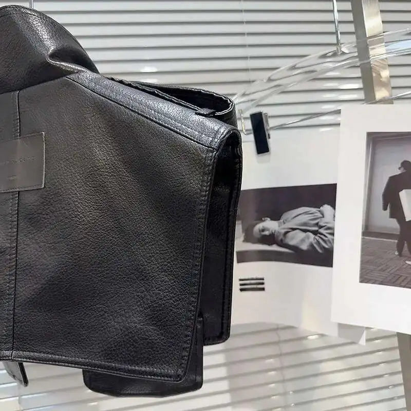 Structured faux leather jacket displayed against a backdrop of fashion photography, showcasing its bold design.