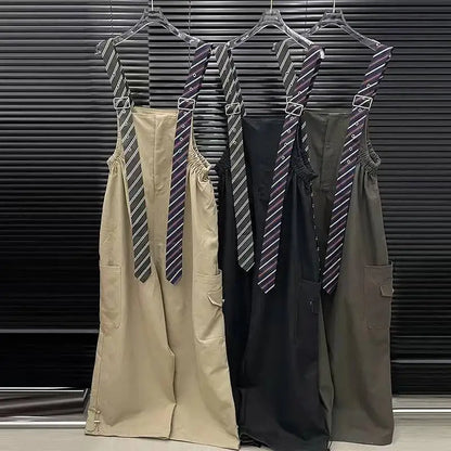 Executive Street Suspender Jumpsuit in beige, black, and olive green hanging on display.