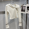 Alt Tag: Asymmetric Zip Sculpt Long-Sleeve Top – Minimalist Streetwear Cutout Tee in white, diagonal zipper neckline, sculpted fit, wrist accents