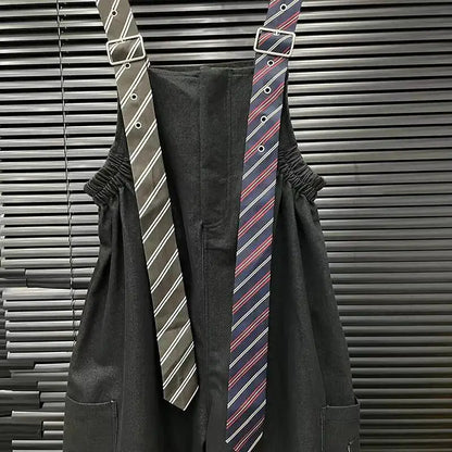 Alt Tag: Executive Street Suspender Jumpsuit black wide-leg high-waist jumpsuit with detachable tie-style suspenders, tailored streetwear look