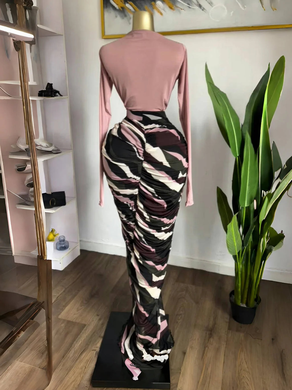 Draped maxi dress showcasing sculpted pleats, fitted knit top, and abstract printed skirt for a dramatic silhouette.