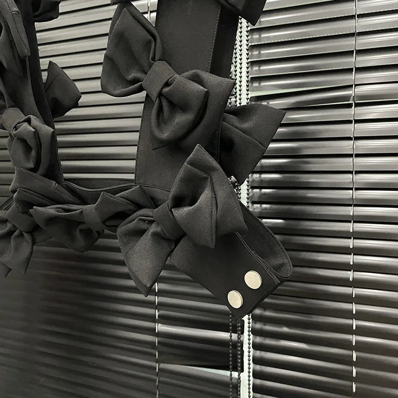 Close-up of the bow cascade crop top showcasing 3D layered bows in black fabric on a stylish background.