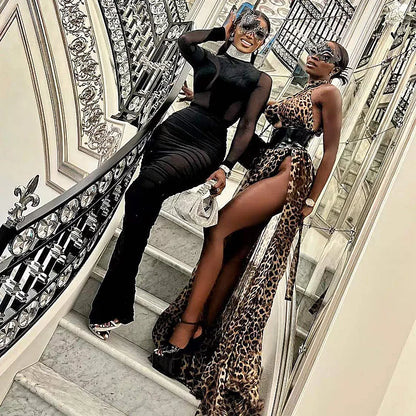 Two women in elegant evening wear, showcasing a Black Velvet + Mesh Illusion style on a grand staircase.