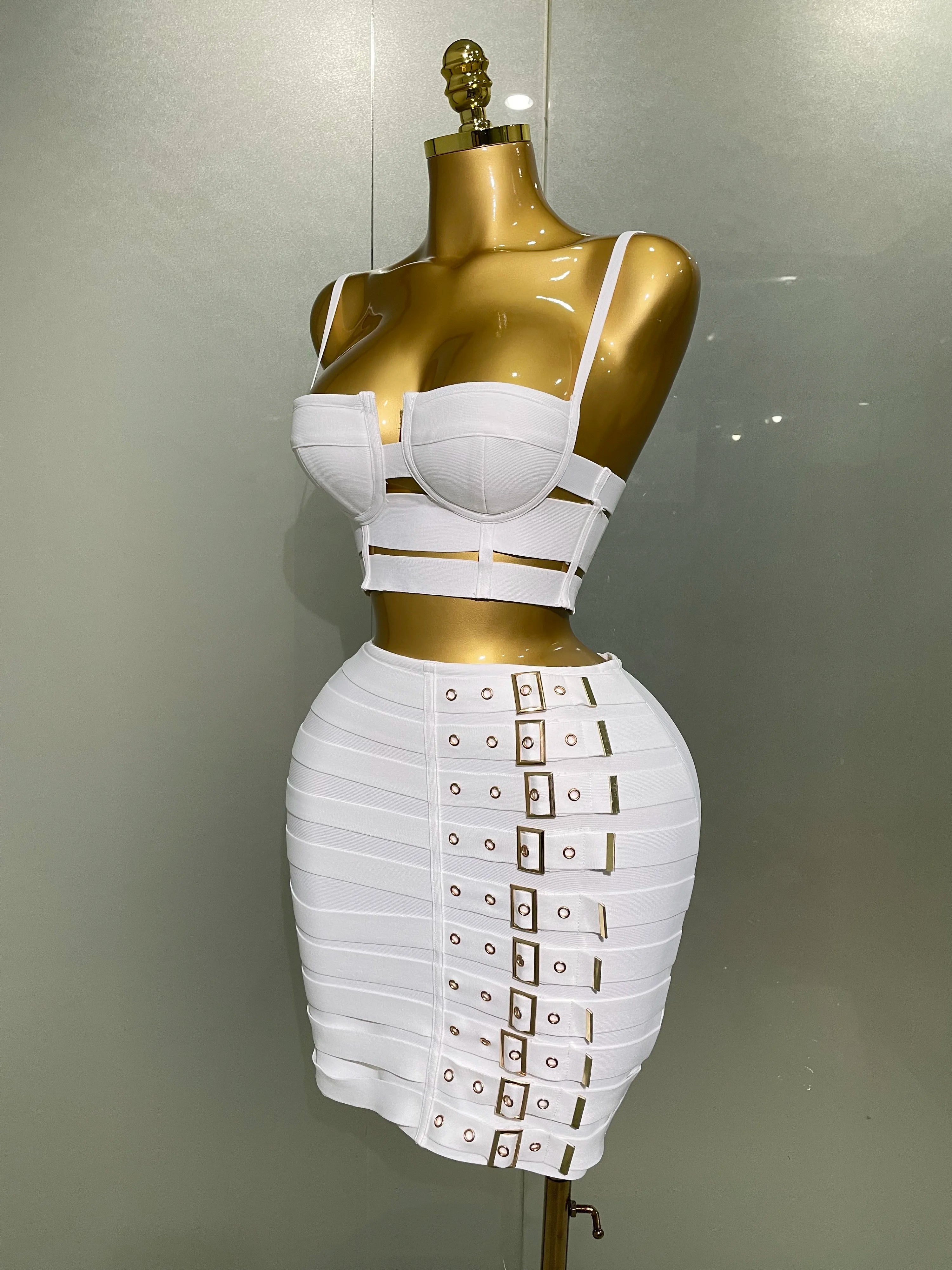 Sculpted bandage two piece set showcased on a mannequin, featuring a stylish top and fitted skirt with buckle details.