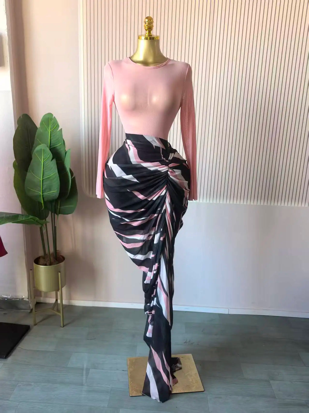 Alt Tag: Sculpted Mirage Draped Maxi Dress with pink fitted knit top, sculpted pleats, and abstract printed draped maxi skirt on mannequin