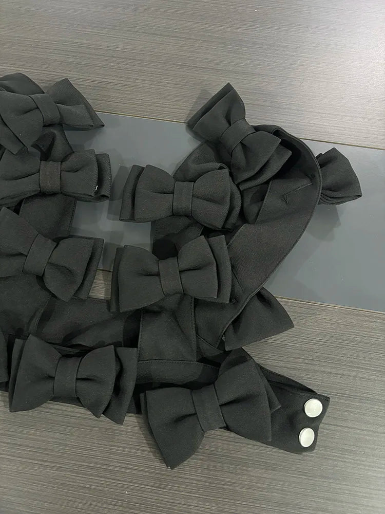 bow cascade crop top featuring layered black 3D bows on a sleek fabric surface.