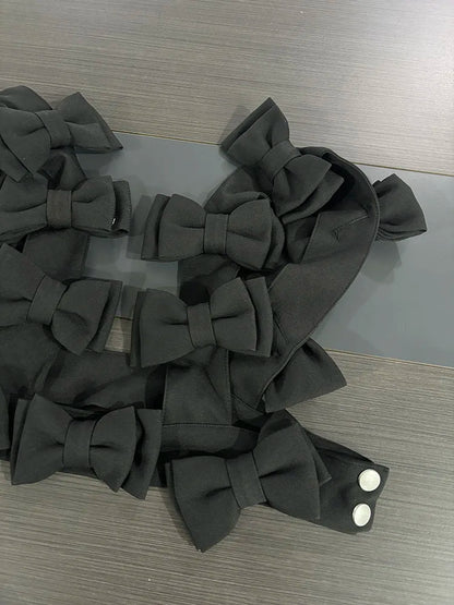 bow cascade crop top featuring layered black 3D bows on a sleek fabric surface.