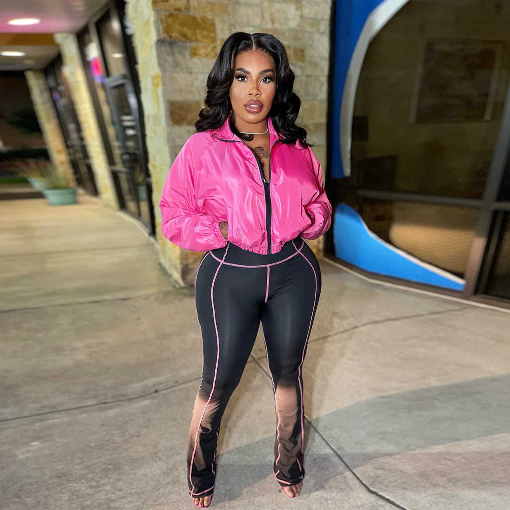 Model showcasing the Velocity Luxe Zip-Front Active Set featuring a glossy pink jacket and contrast stitch leggings.