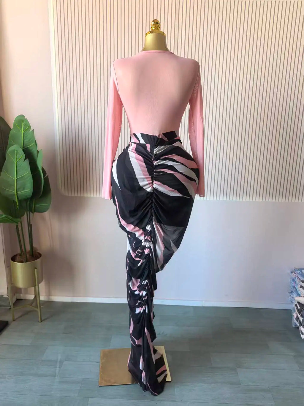 Alt Tag: Sculpted Mirage Draped Maxi Dress on mannequin, back view, fitted knit top with long sleeves and abstract draped skirt