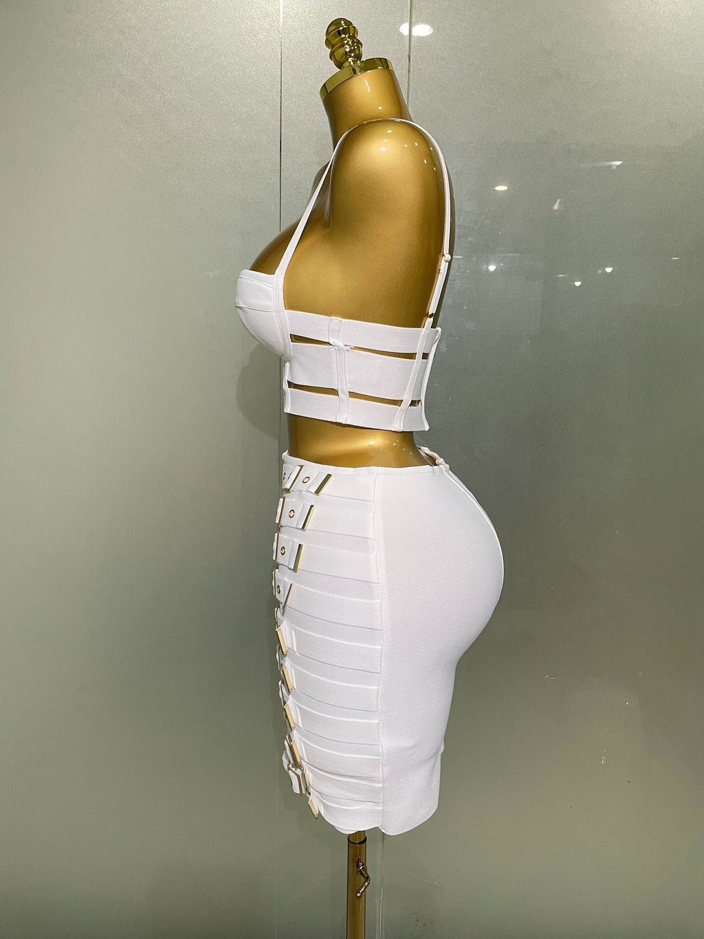 Alt Tag: Sculpted Buckle Bandage 2-Piece Set in white, sculpted bustier crop top and bandage skirt with buckle straps on mannequin