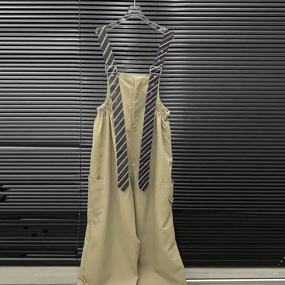 Executive Street Suspender Jumpsuit displayed against a black background showcasing fashionable suspenders and wide-leg design.