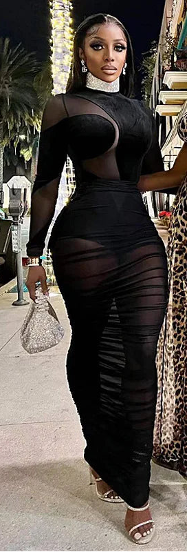 Stylish woman wearing a black velvet illusion maxi dress set with mesh details, perfect for a fashionable night out.
