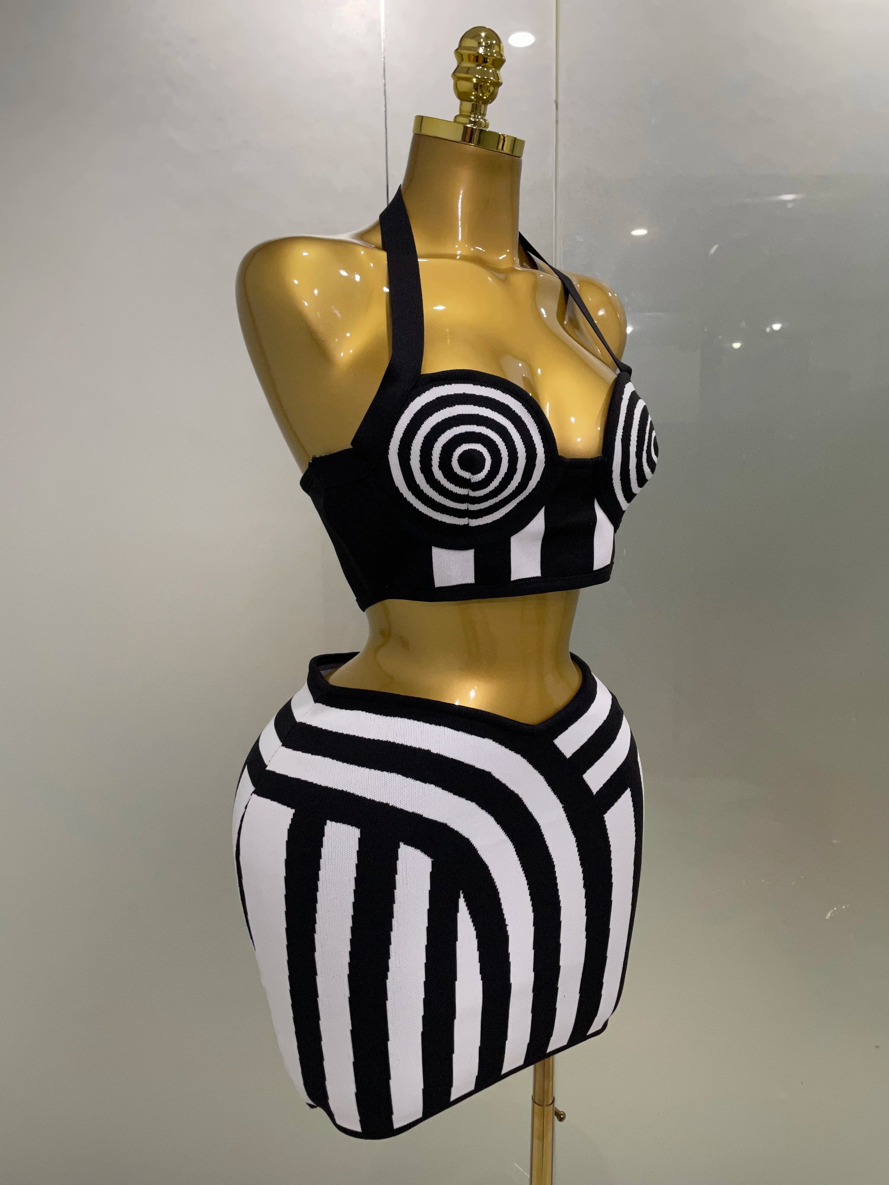 Alt Tag: Optical Illusion Halter Bandage 2-Piece Set on mannequin, black-and-white spiral halter top with matching striped mini skirt