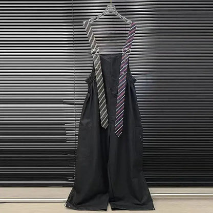 Alt Tag: Executive Street Suspender Jumpsuit black wide-leg high-waist jumpsuit with detachable tie-style suspenders hanging on hanger