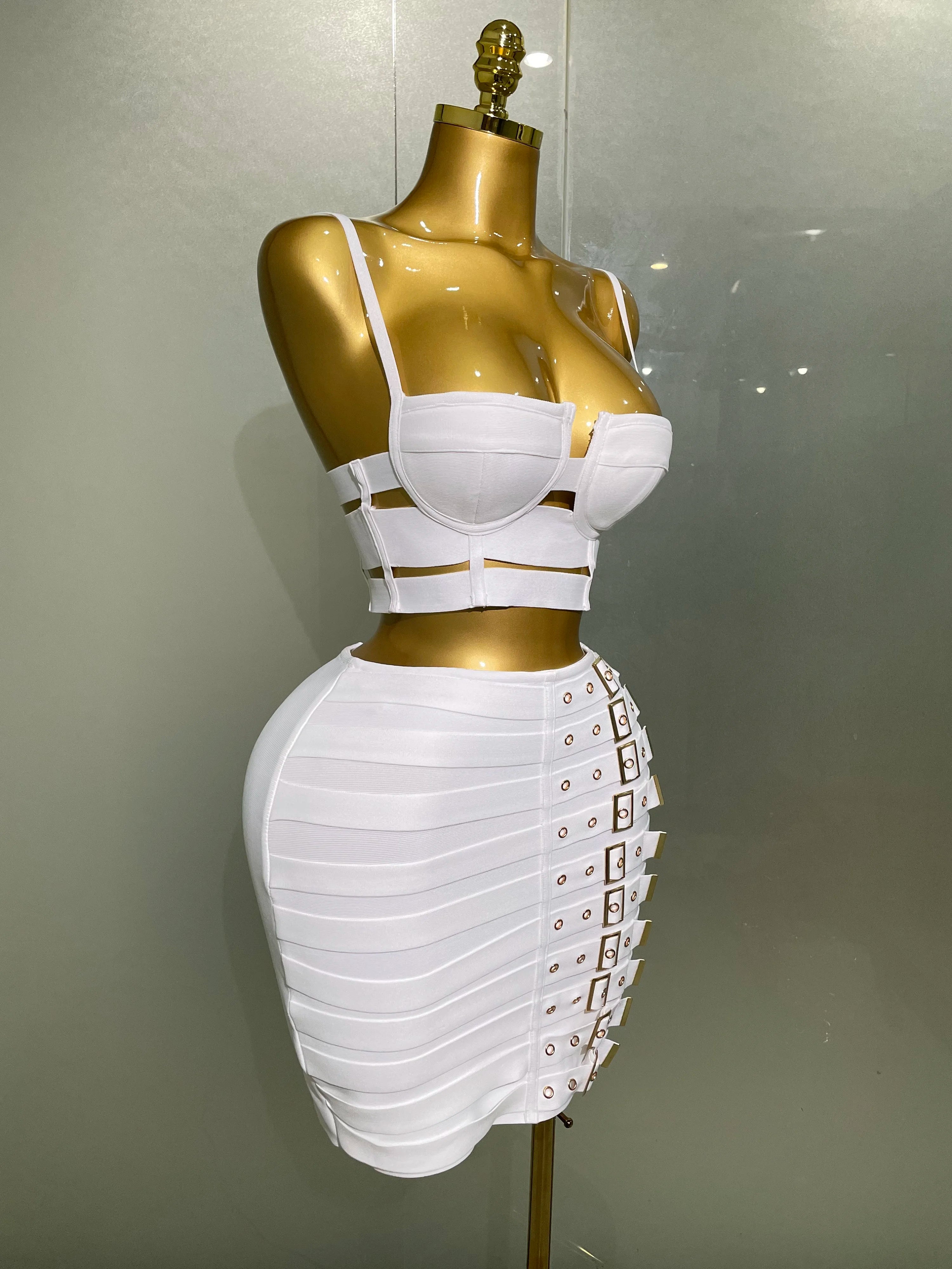 Alt Tag: Sculpted Buckle Bandage 2-Piece Set white bustier crop top and bandage mini skirt with buckle details on mannequin