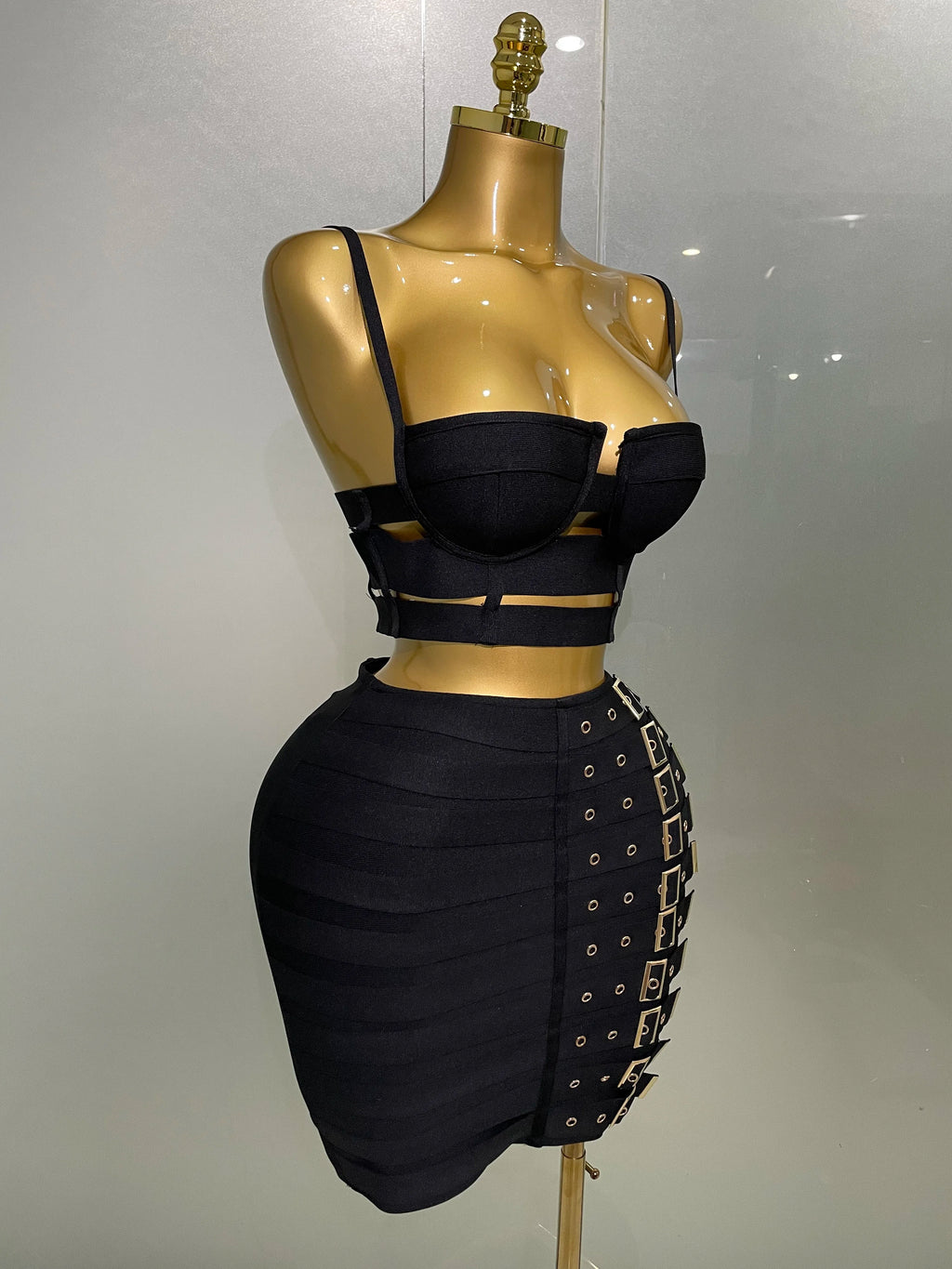 Sculpted Buckle Bandage 2-Piece Set black bandage bustier crop top and high-waist skirt with buckle details on mannequin