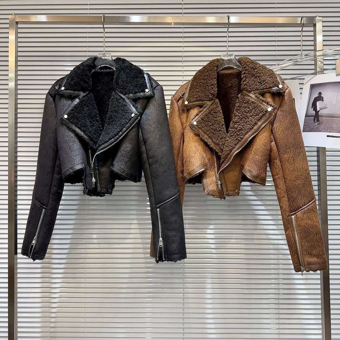 Cropped faux-leather shearling moto jacket in black and brown displayed on hangers, showcasing winter style and bold designs.