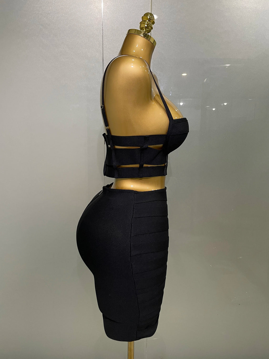 Sculpted Buckle Bandage 2-Piece Set black bustier crop top and high-waist bandage skirt side view on mannequin