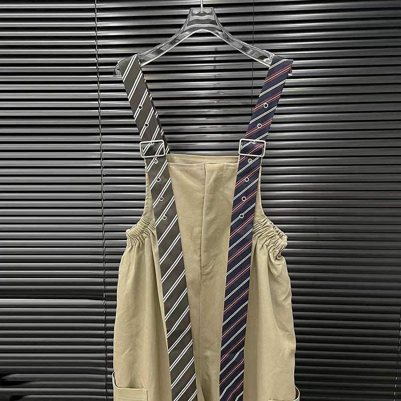 Executive suspender jumpsuit shows stylish tie pattern suspenders against a sleek black backdrop.