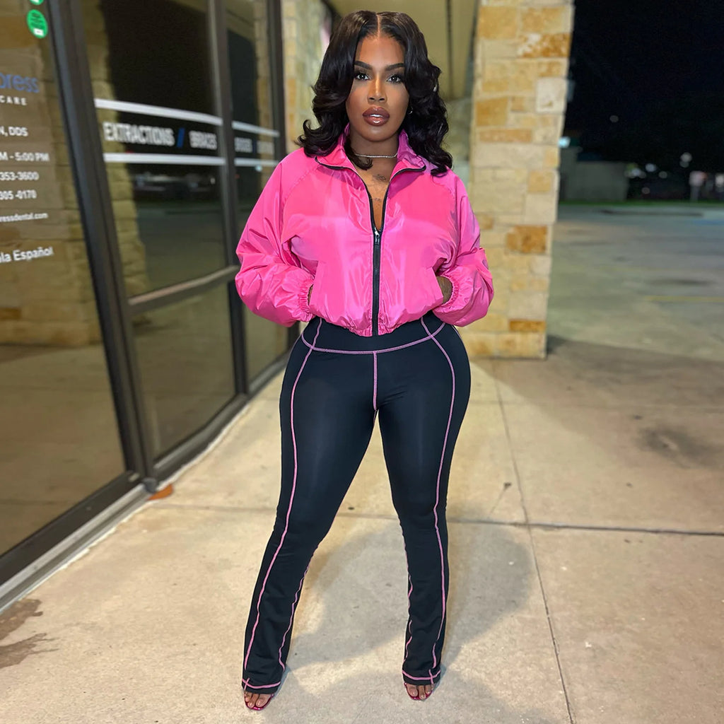 Model wearing a Velocity Luxe Zip-Front Active Set featuring a glossy cropped jacket and contrast stitch leggings.