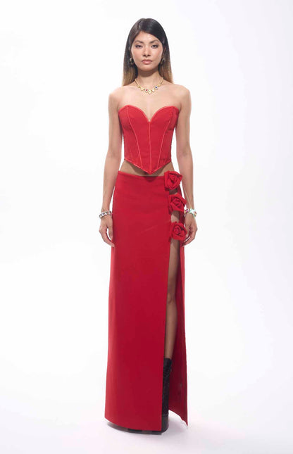 Stunning bandage flower maxi skirt in vibrant red with a high slit and floral accents, perfect for bold fashion events.