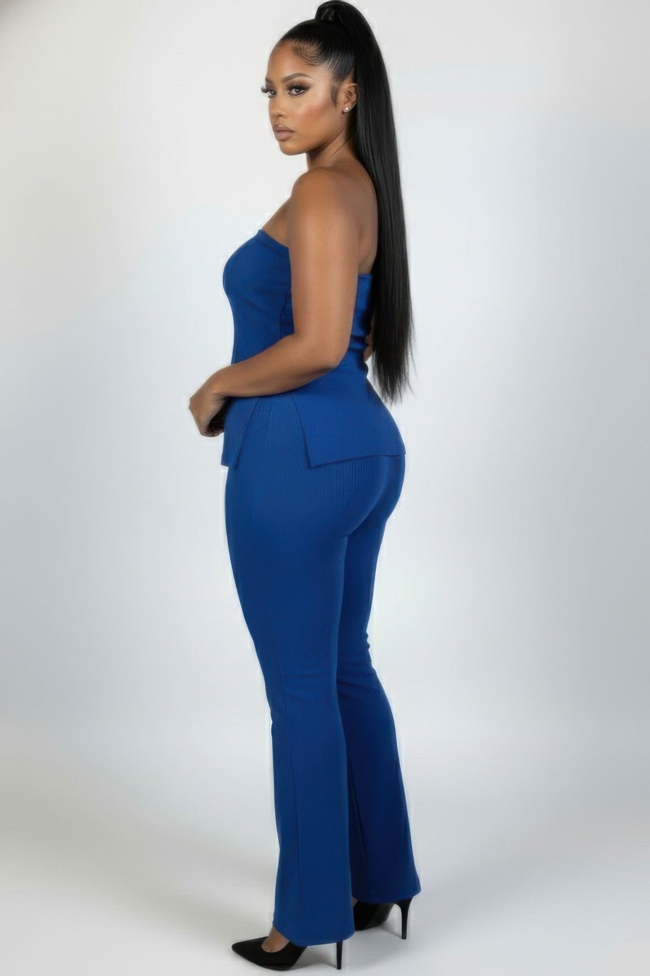 Plus size ribbed tube top and flare pants set in blue from the side in a stylish pose.