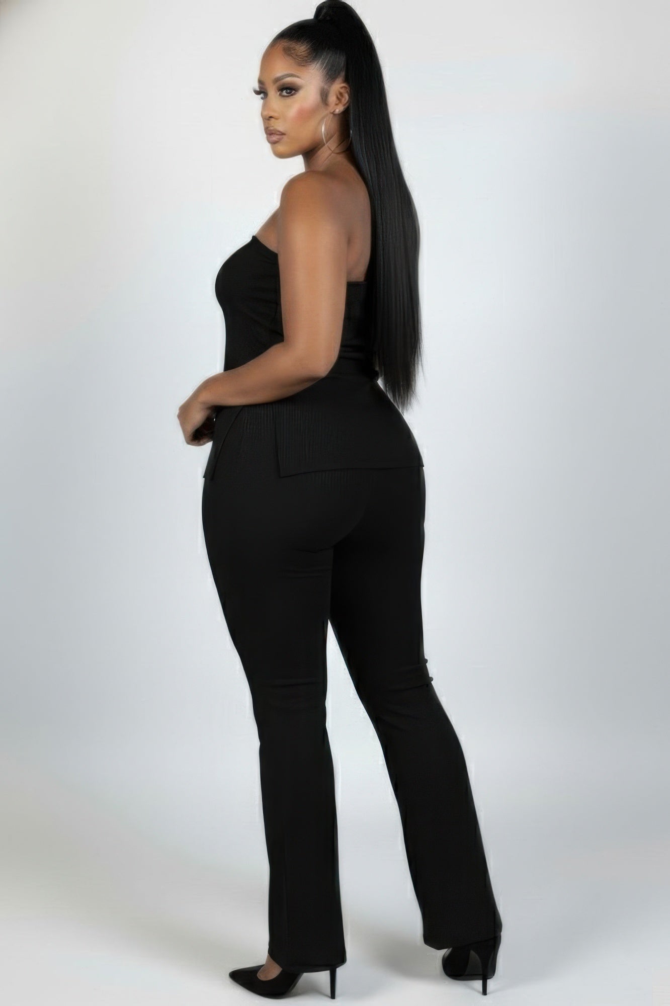 Plus size ribbed tube top and flare pants set model showcasing a sleek look from the back, highlighting stylish curves.