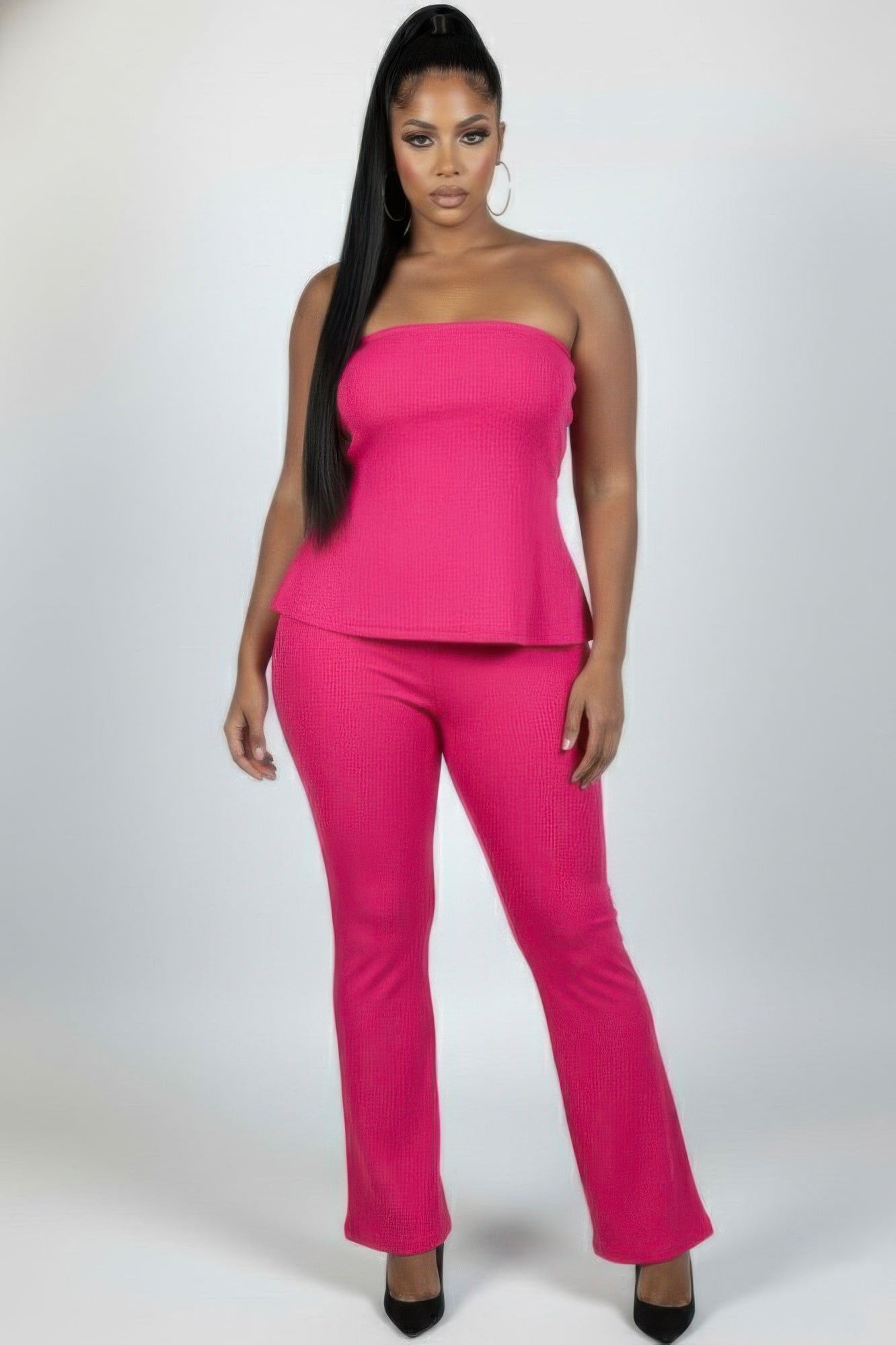 Plus size ribbed tube top and flare pants set in vibrant pink, showcasing a confident and stylish look.