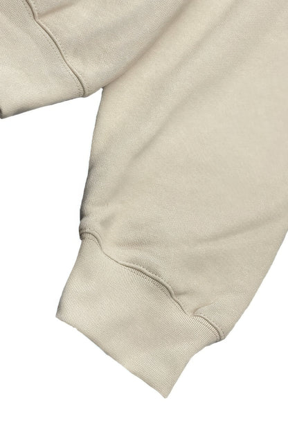 Detail of sleeve cuff from a premium cotton blend hoodie set in soft beige fabric.