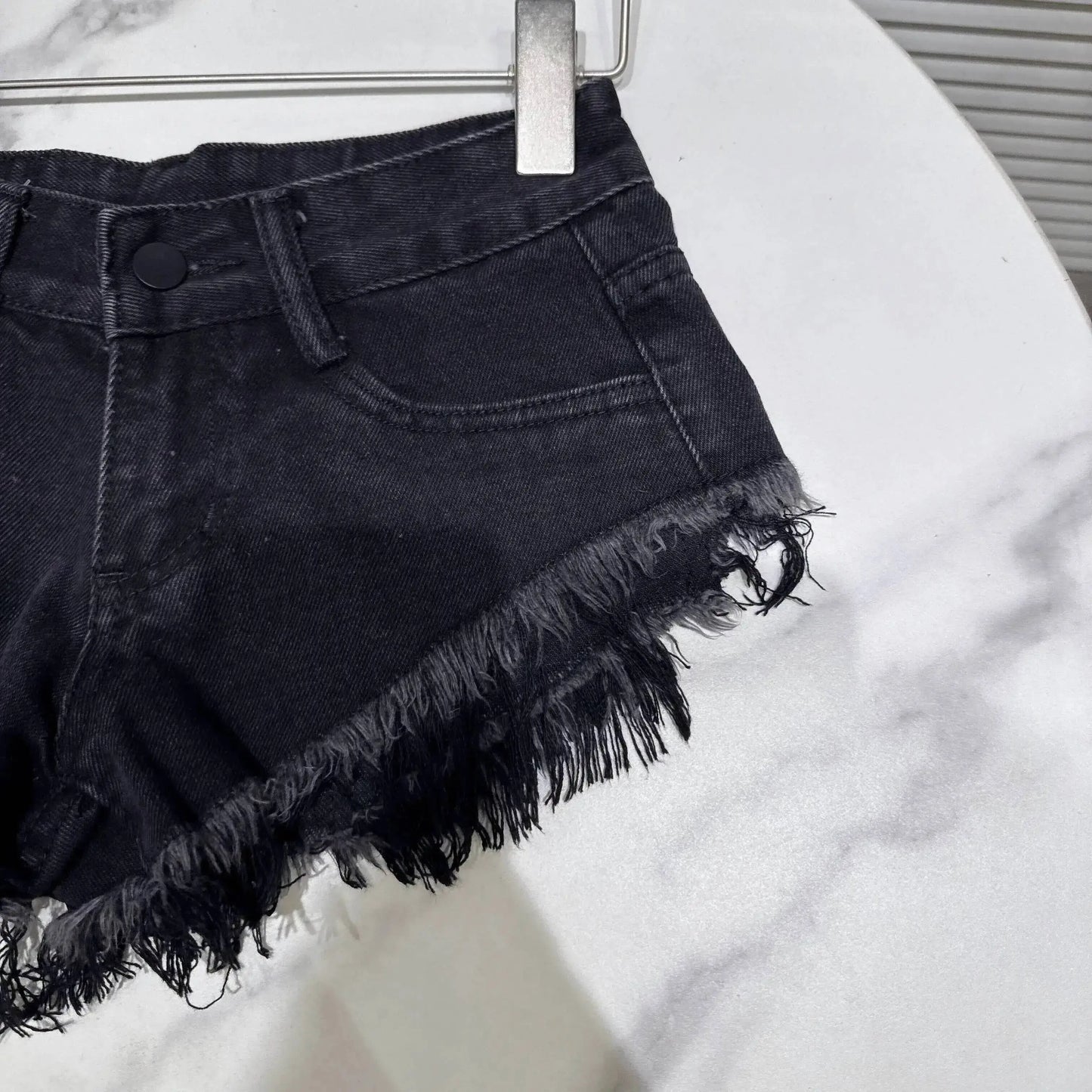 Distressed Raw-Hem Low-Rise Denim Shorts featuring a frayed hem and fitted waist for a stylish summer look.