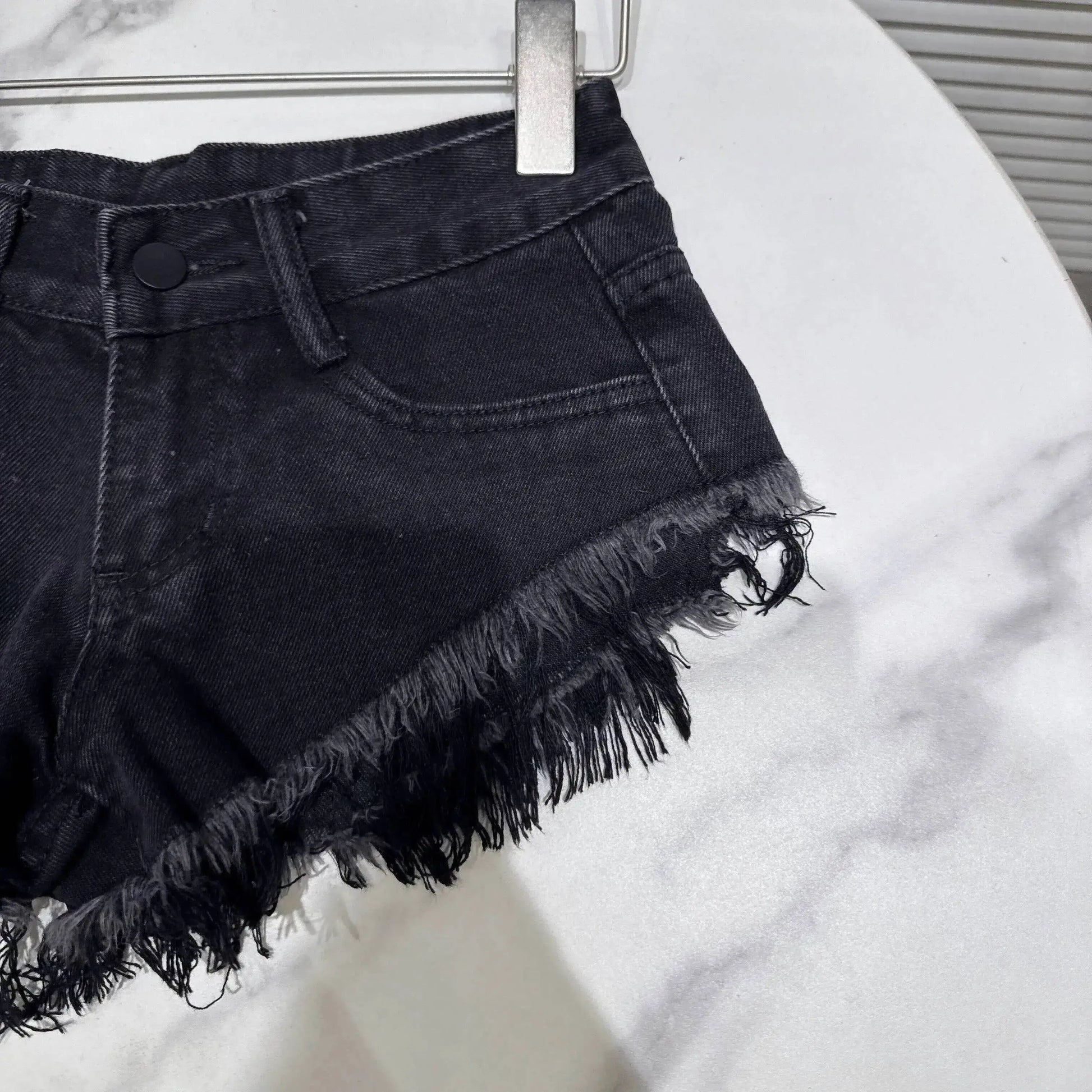 Distressed Raw-Hem Low-Rise Denim Shorts featuring a frayed hem and fitted waist for a stylish summer look.