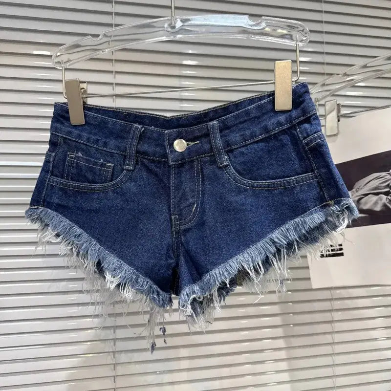 Distressed Raw-Hem Low-Rise Denim Shorts hanging on a display with frayed hem and fitted low-rise waist.