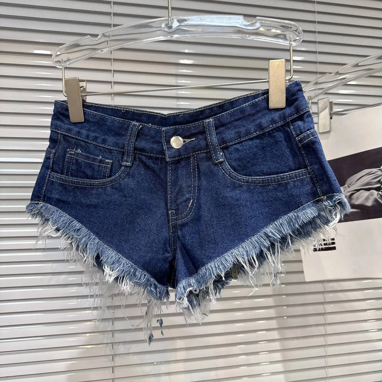 Distressed Raw-Hem Low-Rise Denim Shorts in Navy Blue with frayed hem and classic button-and-zip front.