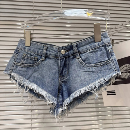 Distressed Raw-Hem Low-Rise Denim Shorts in light blue with frayed hem and fitted low-rise waist.