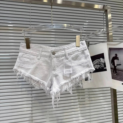 Distressed Raw-Hem Low-Rise Denim Shorts displayed on a hanger with frayed edges and a low-rise waist.