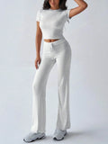 Model wearing a round neck short sleeve top and pants set in light gray, showcasing a stylish and casual look.