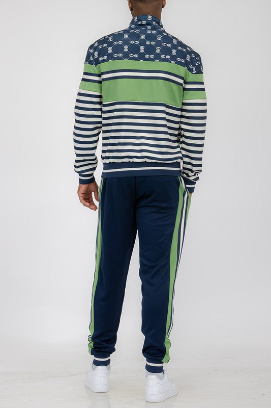 Back view of a man wearing a chain link track suit with striped jacket and jogger pants in navy and green colors.