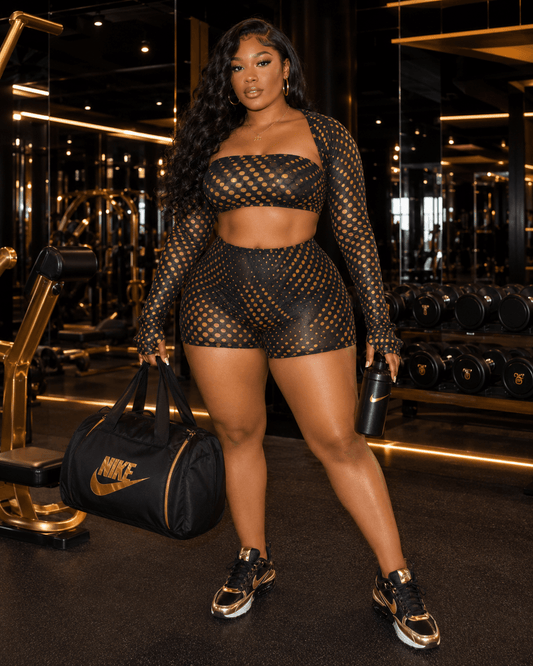 Gold Polka Dot Mesh 3-Piece Crop Top & Shorts Set displayed in a stylish gym setting, showcasing its vibrant design.
