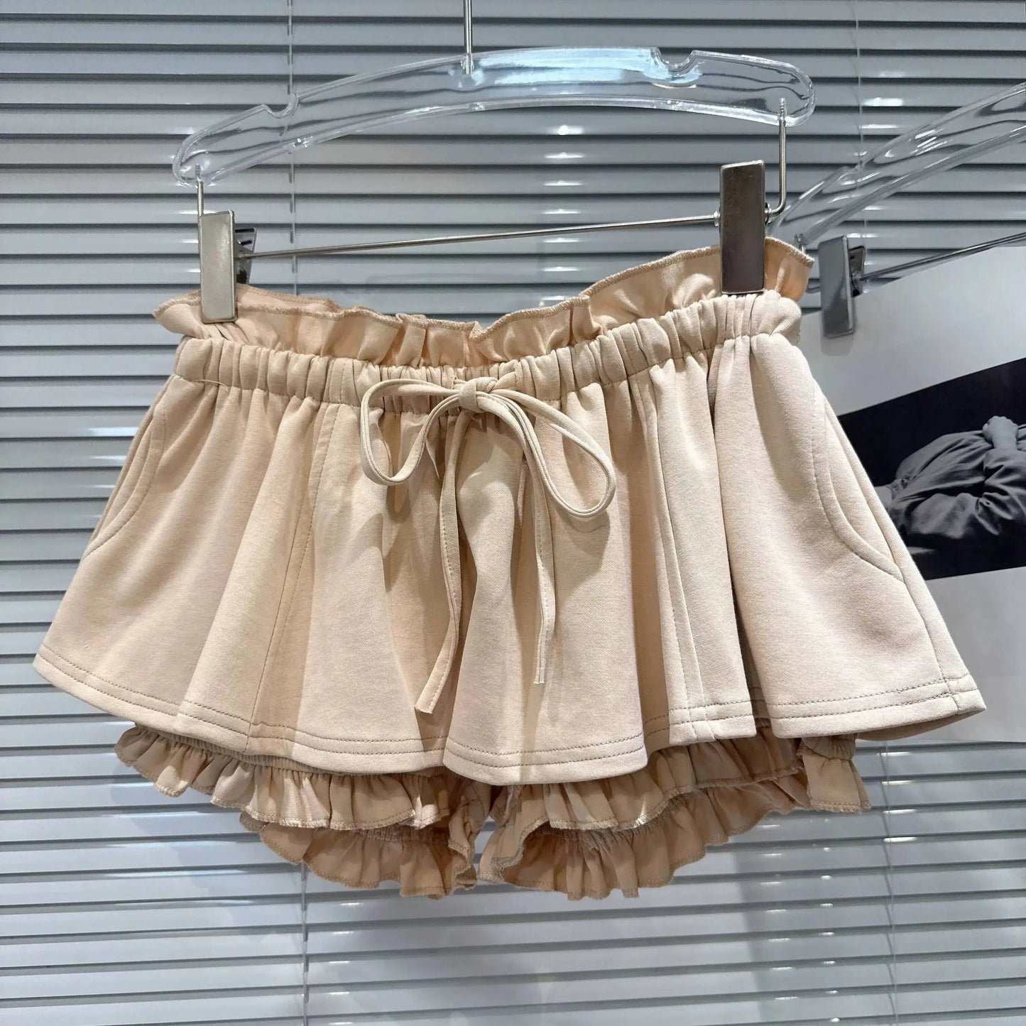 Layered Ruffle Drawstring Mini Skort displayed on a hanger, showcasing its layered ruffles and adjustable drawstring.