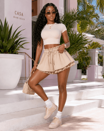 Model wearing Layered Ruffle Drawstring Mini Skort in beige, styled with a fitted top and accessories.