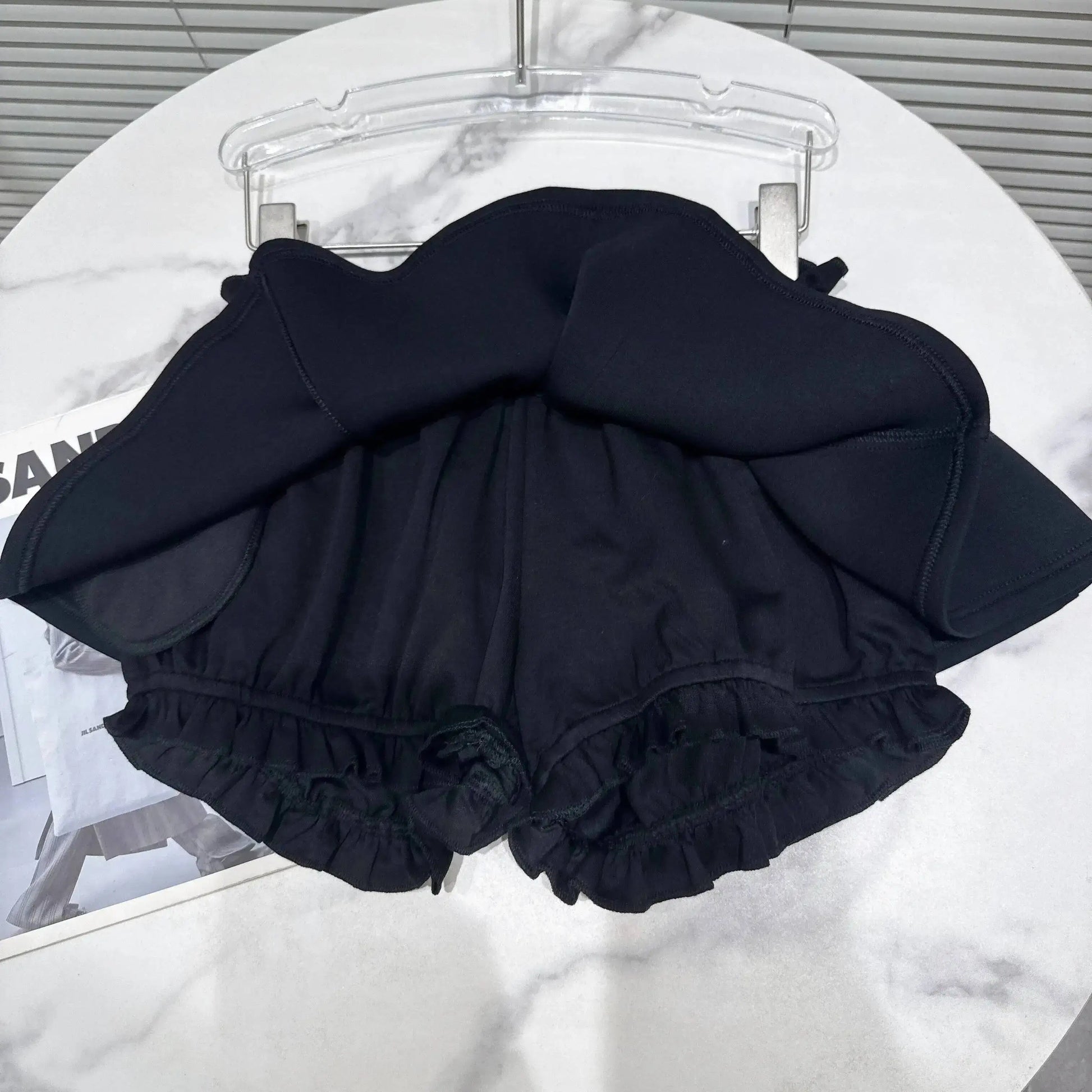 Layered Ruffle Drawstring Mini Skort showing the ruffled layer and shorts-style underlayer in black.
