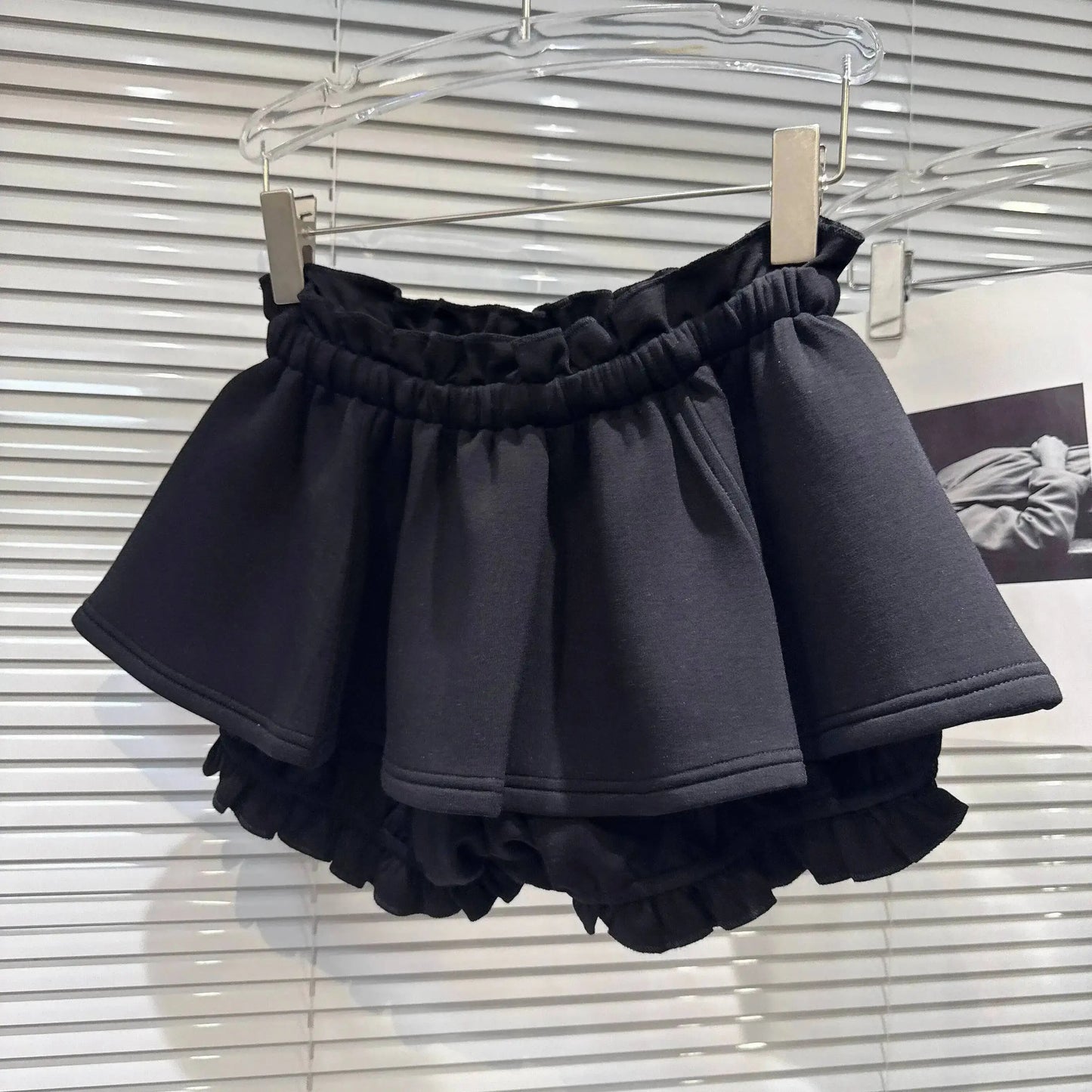 Layered Ruffle Drawstring Mini Skort displayed on a hanger, showcasing its playful ruffle layers and elastic waistband.