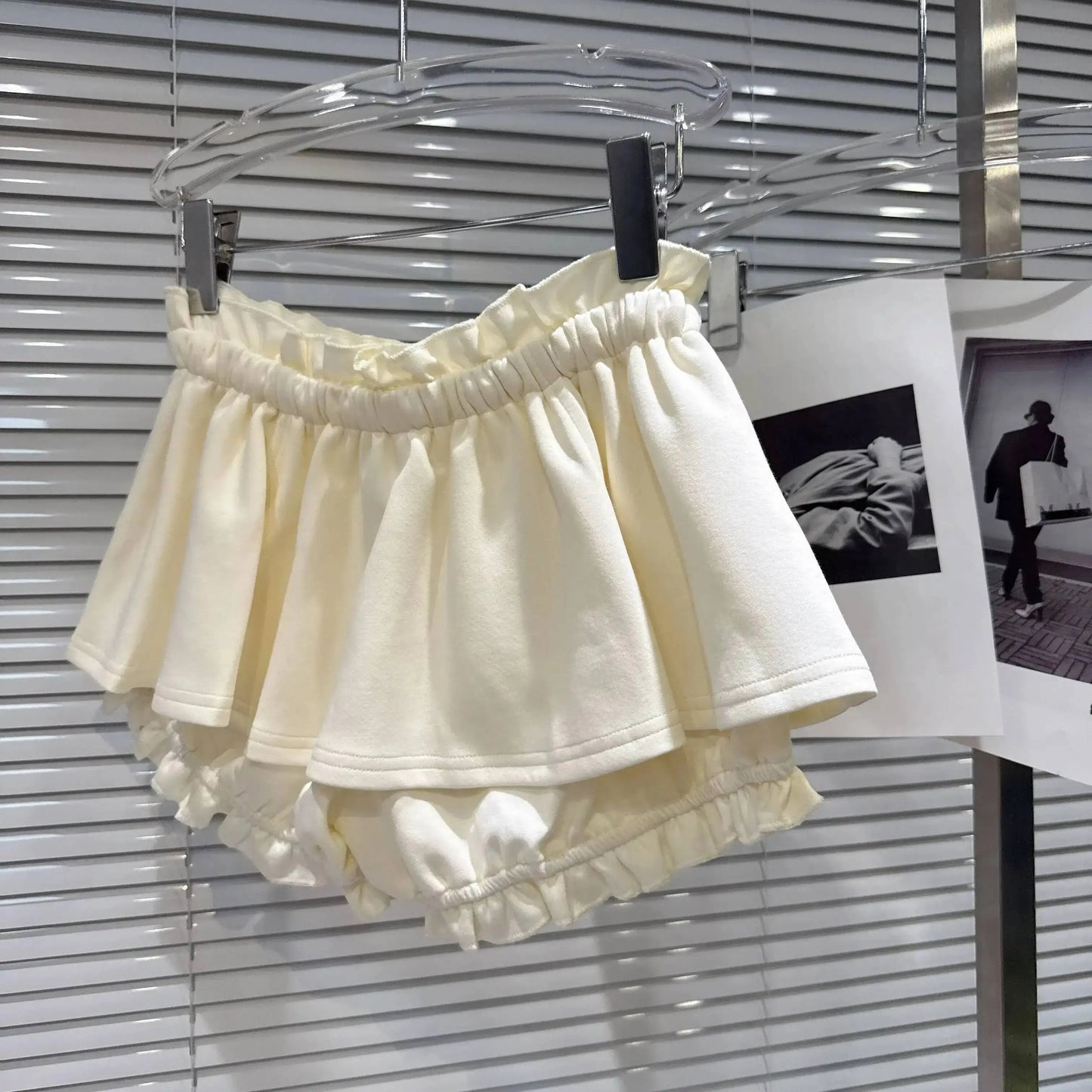 Layered Ruffle Drawstring Mini Skort displayed in soft cream color with layered ruffle details and elastic waistband.