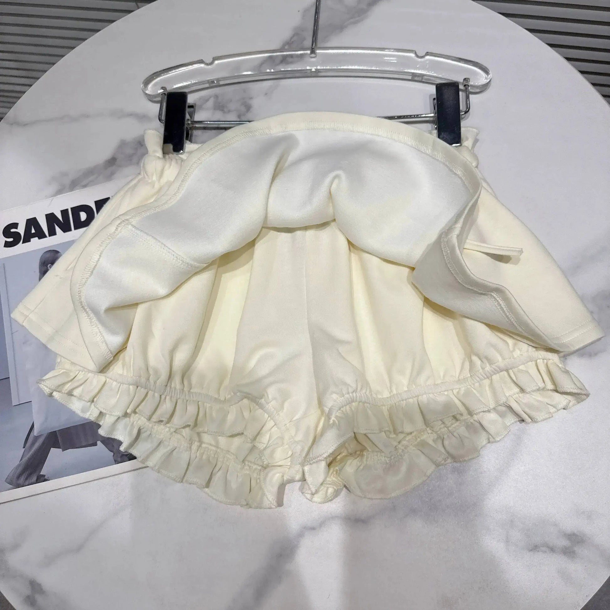 Layered Ruffle Drawstring Mini Skort showcasing ruffled hem and shorts underlayer in a stylish display.